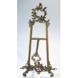 A 19thC style brass table easel, in the rococo manner the 'H' shaped body surmounted by a