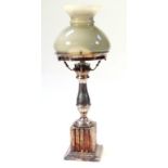 An early 20thC table lamp, with grey glass shade held on a baluster column on a shaped foot, with