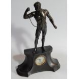 An early 20thC patinated spelter mantel clock, the shaped case surmounted by a scantily clad