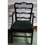 A George III mahogany open arm chair, with a pierced ladder back, scrolling arms and a green leather