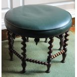 A late Victorian rosewood footstool, with a circular green leather top on spiral turned supports
