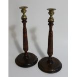 A pair of early 20thC oak candlesticks, with reeded and turned stems, 35cm high.