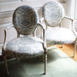 A pair of cream and parcel gilt painted Continental open armchairs, each with a padded back, armrest