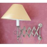 A pair of brass adjustable wall lights, each with a simulated candle fitting, extending to
