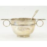 A George V silver twin handled bowl and spoon, monogram engraved, Mappin & Webb, London 1912, cased,