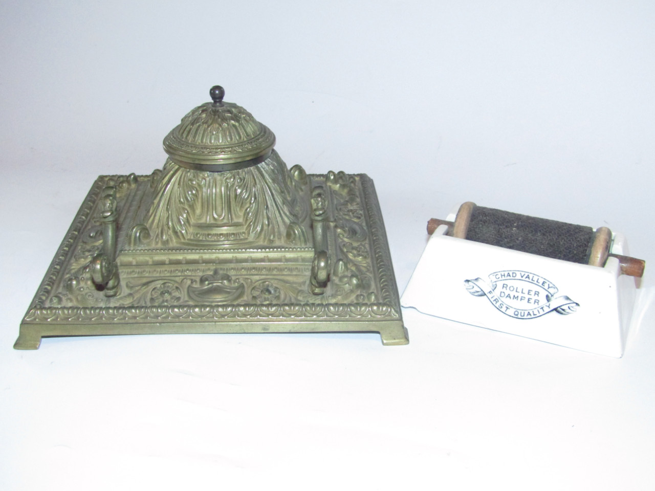 A cast brass desk inkwell, of square form, classically moulded with acanthus scrolls and other
