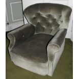 An early 20thC armchair, upholstered in buttoned dralon on castors.