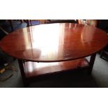 A mahogany coffee table, the oval top with two drop leaves on chamfered supports with rectangular