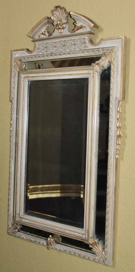 A Continental gilt gesso and painted wall mirror, the top with a broken pediment centred with a