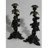 A pair of 19thC cast two colour metal figural candlesticks, depicting a lady with basket and man