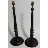 A pair of early 20thC mahogany candlesticks, with reeded columns, 54cm high.