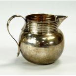 A George V silver milk jug, with reeded handle, London 1912, 14oz.