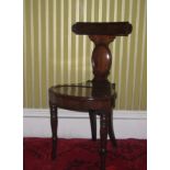 A George IV mahogany hall chair, of klismos type, with a bar back on oval support with shaped