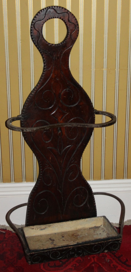 A mahogany umbrella stand, carved with scrolls etc., with a painted drip tray to the base, 106cm