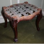 A Victorian mahogany stool, with shaped sides on cabriole legs, headed by leaf carving and