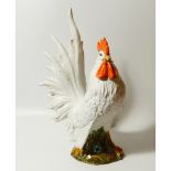 A 20thC pottery figure, of a standing cockerel, picked out in red and yellow with black painted