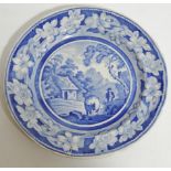 An early 19thC blue and white transfer printed plate, decorated with a farmhand and cow before