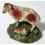 An early 19thC Staffordshire bocage group of sheep and lamb, each picked out in red, the sheep