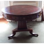 A George IV rosewood and brass inlaid drum top library table, with a red leather insert above four