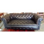 A Victorian Chesterfield sofa, upholstered in dark brown leather, on bun feet, 205cm wide.