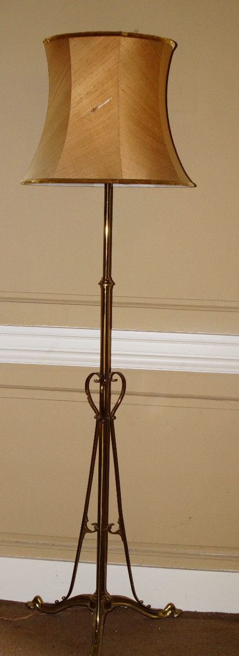 An Art Nouveau style brass adjustable floor lamp, of tubular form with shaped supports and feet,