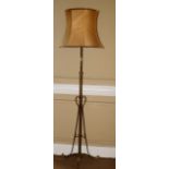 An Art Nouveau style brass adjustable floor lamp, of tubular form with shaped supports and feet,