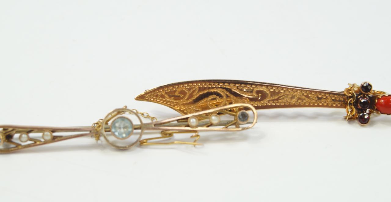 A bar brooch as a scimitar, set with coral and garnet stones to the handle, together with another