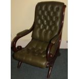 A Victorian mahogany open arm chair, with a padded back, armrest and seat in buttoned green leather,