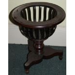 An Edwardian mahogany jardiniere stand, with circular moulded top with slatted supports on a triform