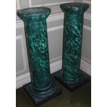 A pair of green simulated marble columns, each with a circular top and cylindrical column, on an