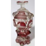 A late 19thC/early 20thC Bohemian ruby flash glass jar and cover, of shaped outline raised with