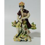 A 19thC Pearlware figure, of a piper aside dog on a bocage ground, polychrome decorated in brown,