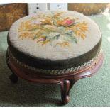 A Victorian footstool, with a padded circular woolwork seat on four cabriole legs, 30cm dia.