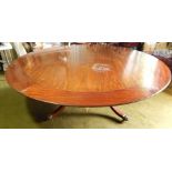 A mahogany dining table in Regency style, the circular top with loose outer leaves and on shaped