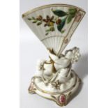 A 19thC Continental porcelain centrepiece, formed as a cherub holding fan, polychrome decorated with