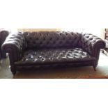 A Victorian Chesterfield sofa, upholstered in buttoned dark brown vintage style leather on turned