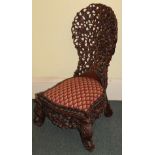 A 19thC Burmese hardwood spoon back side chair, carved overall with leaves, etc., with a padded seat