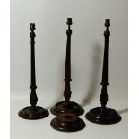 A pair of mahogany candlesticks, with slender fluted and tapered columns and circular bases, and