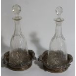 A pair of cut glass mallet decanters, with prismatic stoppers and a pair of silver plated rococo