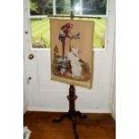 A Victorian walnut pole screen, with a later banner depicting terrier, parrots etc.,on a brass