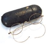 A pair of Edwardian spectacles, with plain glazed lenses and curved side bars, with a shaped bridge,