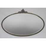 A 19thC style hanging mirror, the oval bevelled glass on a plain metal outline, surmounted by an