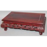 A Chinese hardwood low table, the rectangular overhanging top raised above a pierced frieze and