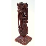 A heavily carved hardwood lamp base, formed as a serpent devouring another animal, on a square base,