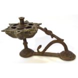 A Middle Eastern metal candlestick, with floral pierced dish holder on an entwined double domed