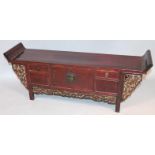 A Chinese stained hardwood low alter table, the shaped rectangular top held by pierced floral