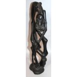 A 20thC carved African ebonised tribal hardwood figure, of a gentleman with entwined limbs on shaped