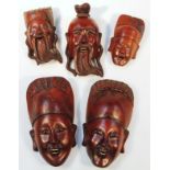 A quantity of Tibetan and other hardwood face masks, to include a figure in elaborate headdress 25cm