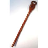 A 20thC carved Arfican tribal staff, with ring top the serpent entwined stem surmounted by a