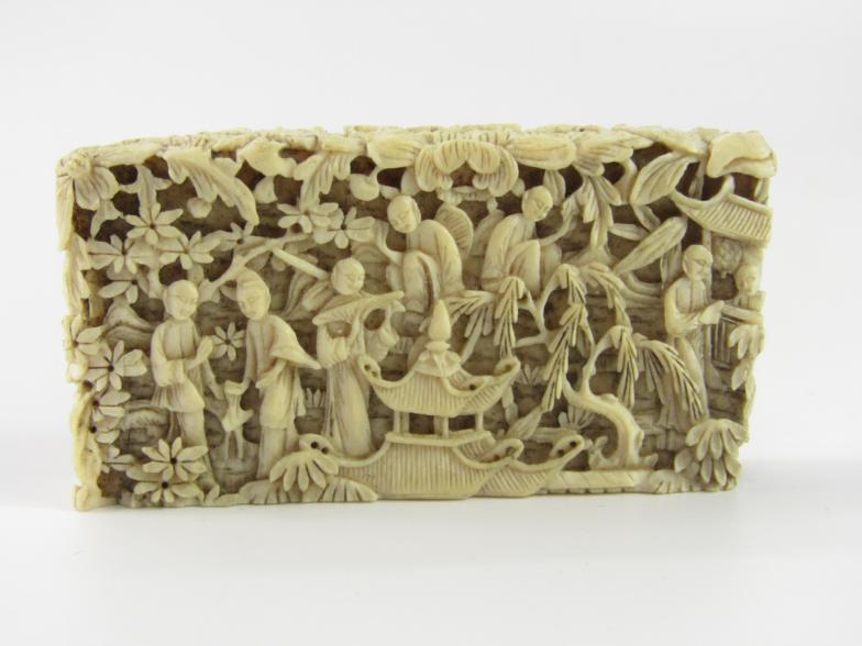 A Cantonese late 19thC ivory card sleeve, carved with figures in a garden, 7cm x 3.5cm, (AF).
